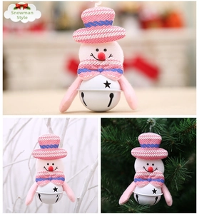 Pink plush snowman ornament with white star bell hanging on a Christmas tree