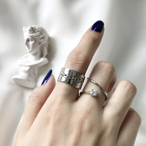 Detail of silver S925 ring set with cubic zirconia and chain texture on model hand