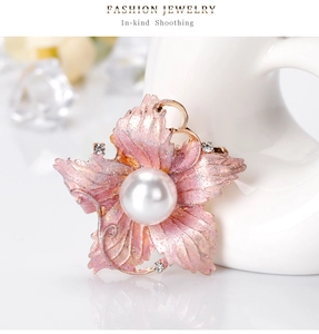 Detailed macro shot of a pink floral brooch with shimmering petals and central pearl