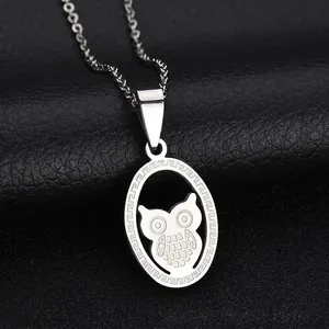 Macro shot of stainless steel necklace with laser-cut owl pendant on black leather surface