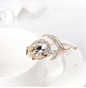 Close-up of golden tulip brooch with large teardrop crystal and sparkling petite diamonds