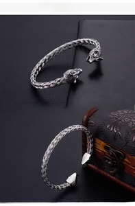 Macro detail of viking wolf heads and braided stainless steel texture on punk bracelet