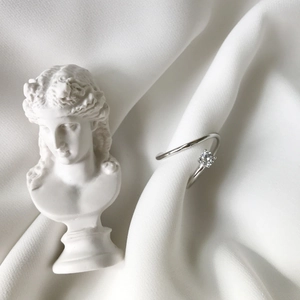 Macro detail of twisted S925 silver ring with sparkling zircon in silk setting