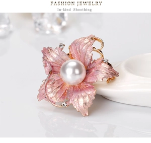 Detail view of pink matte flower brooch with sparkling glitter and white pearl center