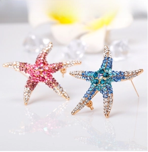 Detailed close-up of starfish brooches with pink and blue rhinestones in rose gold