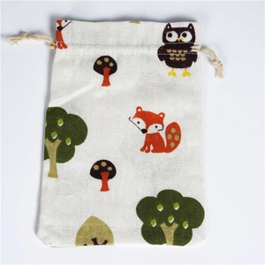 Detail of small cotton linen drawstring bag with cartoon fox and owl forest patterns