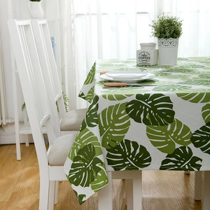 Detailed close-up of thick cotton-linen tablecloth with green monstera leaf patterns