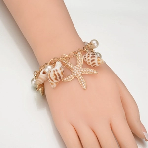 Armband im Ozean-Stil mit goldenem Seestern, Muscheln und Perlen am Handgelenk
