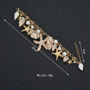 Bohemian ocean charm bracelet with starfish, striped shells, and pearls in gold finish