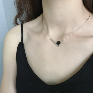 Close-up of minimalist 925 sterling silver necklace with black agate square bar pendant