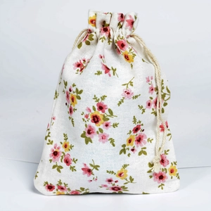 Detail of floral cotton linen drawstring bag with colorful patterns and wooden beads
