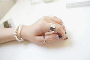 Detail of S925 sterling silver twist ring and minimalist beaded bracelet on model
