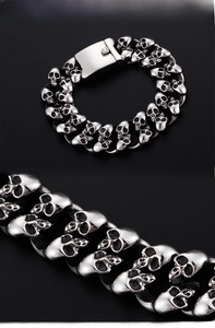 Macro detail of men's stainless steel skull link bracelet with sturdy push clasp