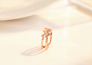 Close-up of rose gold double-layer lightning ring with micro-pave crystal accents