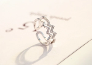 Macro shot of double-layered wavy silver ring with crystal pave and polished band detail