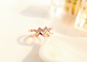 Macro detail of rose gold double-layered wave ring with sparkling crystal pave setting