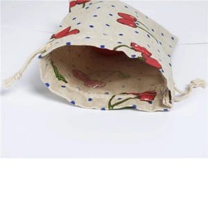 Detail of cotton linen drawstring pouch with red cherry and blue polka dot patterns