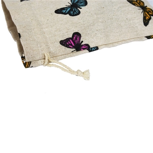 Close-up of linen drawstring bag with colorful butterfly prints and functional cord