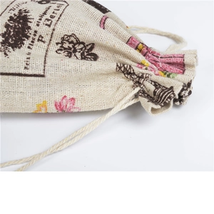 Detail of beige linen drawstring pouch with vintage floral print and texture close-up