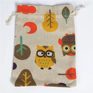 Detailed view of linen drawstring bag with colorful owl and tree patterns on white background