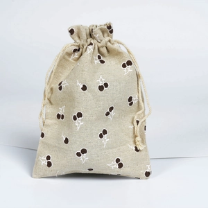 Close-up of beige linen drawstring bag with cherry patterns for jewelry storage