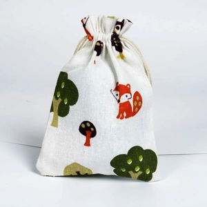 Detail of cotton drawstring bag with red fox, green tree, and mushroom prints