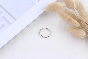 Detail of S925 silver twisted rope ring on a white fabric and magazine background