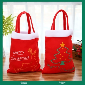Détail de sacs cadeaux de Noël en velours rouge avec motifs de renne et sapin doré