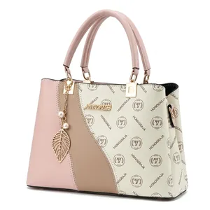 Détail d'un sac cabas tricolore pour femme avec motif monogramme et pendentif