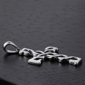 Polished silver stainless steel cross pendant necklace on a black textured background