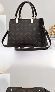 Detailed view of dark brown textured leather handbag with gold buckles and logo pattern