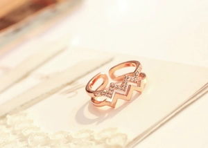 Macro detail of rose gold double-layer wave ring with shimmering pavé crystal accents