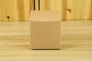 Detailed view of 10cm brown kraft paper candy box with natural wood grain background