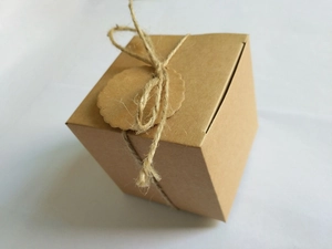 Detailed view of brown kraft paper candy box with jute twine and a blank scalloped tag