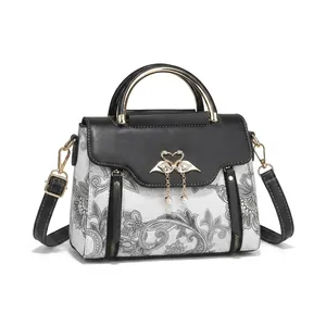 Détail de sac à main paisley avec boucle cygne en cœur et pendentif perle