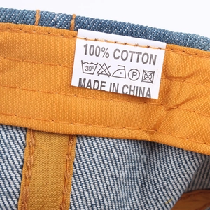 Dettaglio del berretto in denim lavato con fascia in cotone e cuciture rifinite