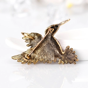 Hummingbird brooch pin in vintage gold alloy with detailed feather textures and pin clasp