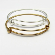 Detail view of adjustable hollow round initial bracelets in polished gold and silver finishes