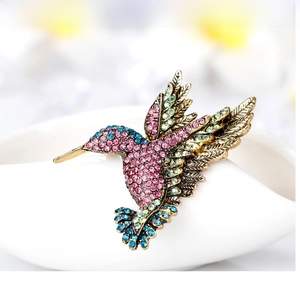 Macro shot of colorful rhinestone hummingbird brooch in gold-plated finish