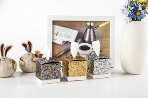 Close-up of three glitter paper candy boxes in gold and silver for wedding favors