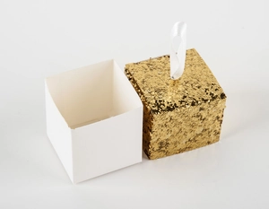 Macro view of square glitter candy box with white base and satin ribbon handle