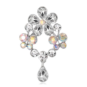 Detail of silver floral brooch with blue rhinestones and sparkling crystal petals