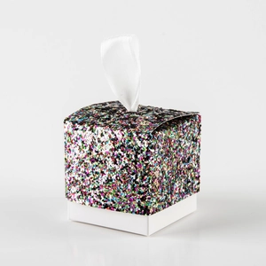 Macro detail of white wedding candy box with colorful glitter lid and satin ribbon