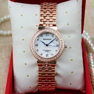 Close-up of a rose gold diamond watch with mother-of-pearl dial in a luxury red gift box
