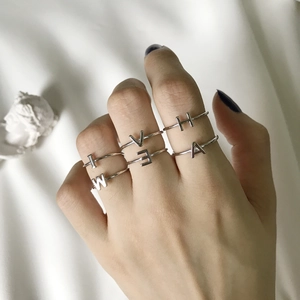 Minimalist 925 sterling silver handmade wire wrapped alphabet rings worn on a hand