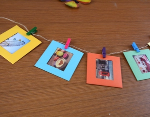 Close-up of colorful paper photo frames with mini wooden clips and natural jute rope set