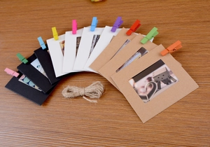 DIY paper photo frames set with colorful wooden clips and hemp rope on a wood desk