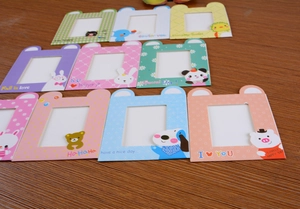 Close-up of colorful cartoon animal paper frames with patterns on dark wood background
