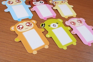 Detail view of 6 colorful cartoon animal paper frames on a dark wood texture desk