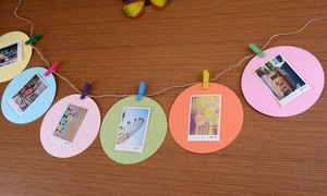 Detail of colorful round paper photo frames with mini wooden clips and jute rope